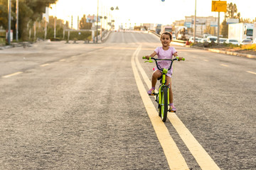 Cute little girl learning ride a bicycle. Spring/summer/autumn active sport leisure for kids. Toddler kid on bike