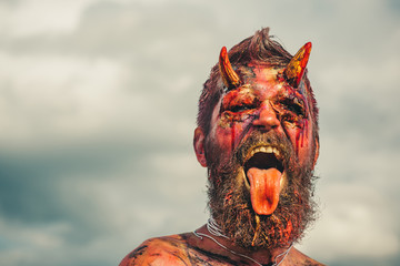 Halloween demon man with beard showing tongue