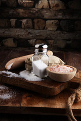 Salt Shaker and salt on wooden table.