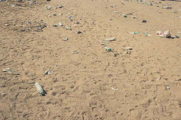 earth pollution result of human activity concept of many garbage objects on dirty sand background texture with empty space for copy or text