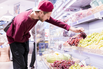 portrait of handsome bearded young man buying some food in the store