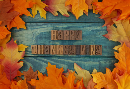 Happy Thanksgiving Background with Fall Leaves on Blue Wood