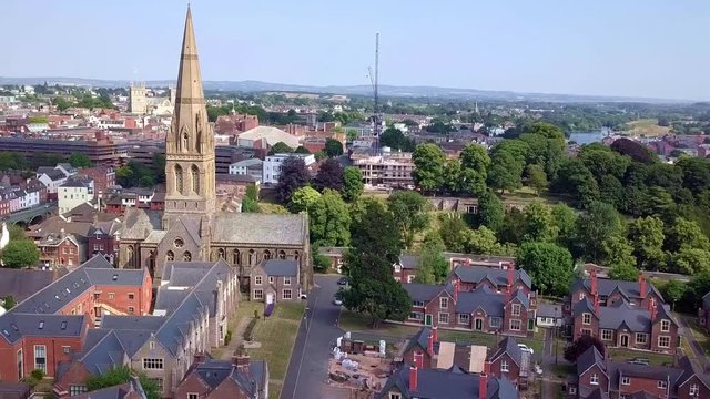 Aerial pan past an old church in Exeter, England
