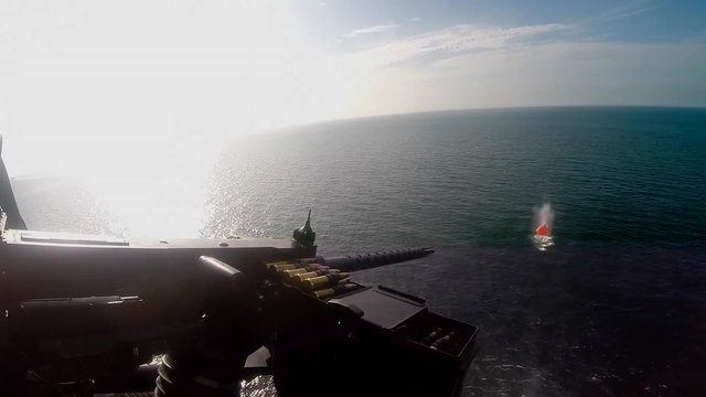 live fire exercise training with 12,7 mm machine gun froma a sh60 helicopter at sea while deployment.