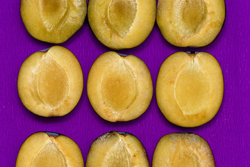 juicy plum slices on a purple background