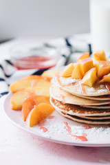 Stack of delicious homemade pancakes with sauce and sliced apple