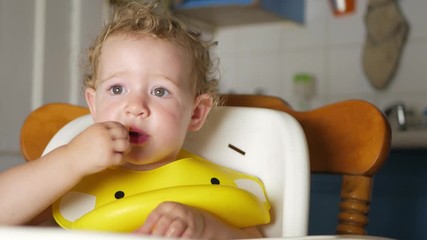 baby eating in high chair puts heritage tomato in mouth then uses sign language to ask for more - Powered by Adobe