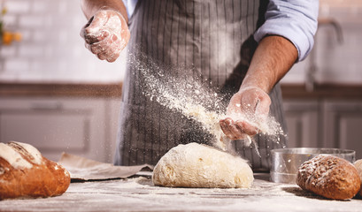 les mains du mâle du boulanger pétrissent la pâte