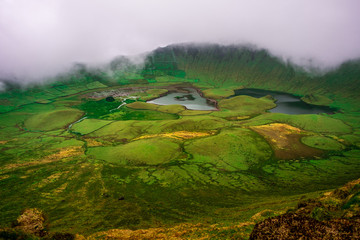 A view to the bottom of the cauldron of Corvo Island in Azores with some Clouds