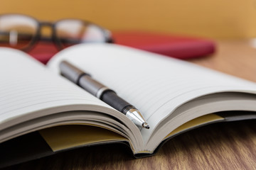 book with pen, mobile and keyborad on desk