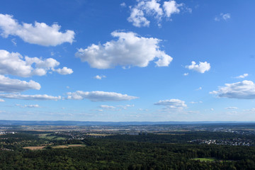 Amazing Landscape view on the beautiful forests, alpine mountains and idyllic fields of South Germany with a blue sky before sunset with clouds