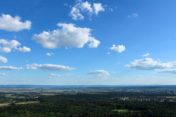 Amazing Landscape view on the beautiful forests, alpine mountains and idyllic fields of South Germany with a blue sky before sunset with clouds