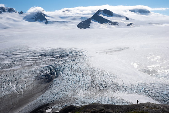 Hiker dwarfed by Alaska's Harding Icefield 