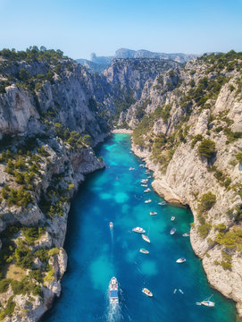 Yachts at the sea in France. Aerial view of luxury floating boat on transparent turquoise water at sunny day. Summer seascape from air. Top view from drone. Seascape with motorboat in bay. 
