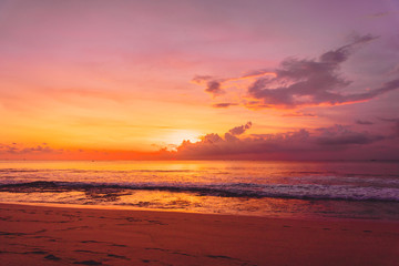 Fototapeta na wymiar Colorful bright sunset or sunrise at sandy beach with ocean in California