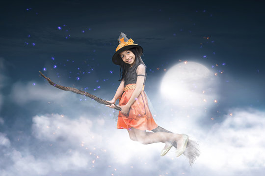 Happy asian witch girl flying on broomstick