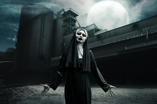 Scary asian devil nun standing on abandoned old factory