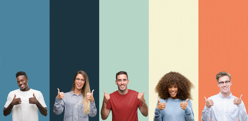 Group of people over vintage colors background success sign doing positive gesture with hand, thumbs up smiling and happy. Looking at the camera with cheerful expression, winner gesture.