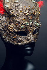 Golden mask with precious stones and feathers