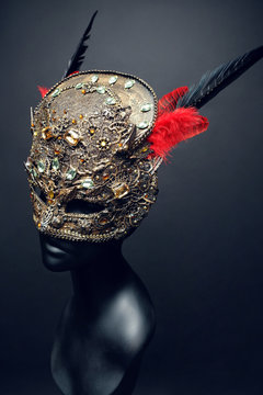 Golden mask with precious stones and feathers