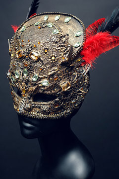 Golden mask with precious stones and feathers