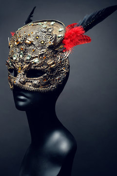 Golden mask with precious stones and feathers