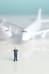 Miniature figures of a successful businessman with air transport background.