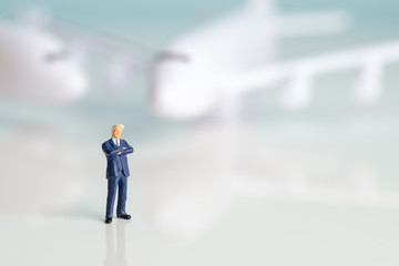 Miniature figures of a successful businessman with air transport background.