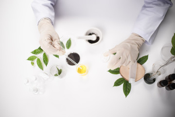 doctor woman scientist making herbal medicine in lab with herb leaves vitamin supplements mineral...