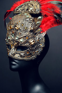 Golden mask with precious stones and feathers