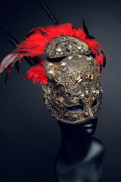 Golden mask with precious stones and feathers