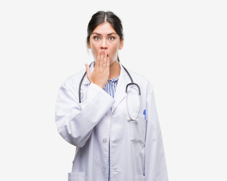 Young hispanic doctor woman cover mouth with hand shocked with shame for mistake, expression of fear, scared in silence, secret concept