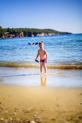 Fototapeta na wymiar Adorable kid play on the beach at sea