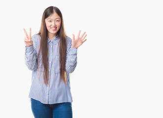 Young Chinese woman over isolated background showing and pointing up with fingers number seven while smiling confident and happy.
