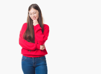 Young Chinese woman over isolated background wearing glasses looking confident at the camera with smile with crossed arms and hand raised on chin. Thinking positive.