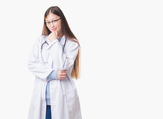 Young Chinese doctor woman over isolated background looking confident at the camera with smile with crossed arms and hand raised on chin. Thinking positive.