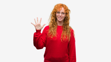 Obraz na płótnie Canvas Young redhead woman wearing red sweater showing and pointing up with fingers number five while smiling confident and happy.