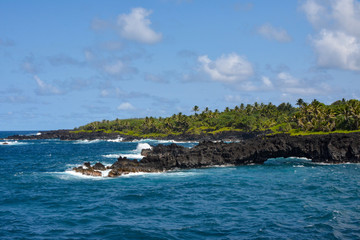 Naklejka premium Sea arch along the coast at Waianapanapa Black sand beach state park on the road to Hana in Maui, Hawaii.