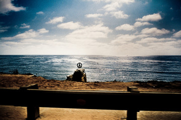 Fototapeta na wymiar pace sign next to the shore from the road somewhere at California, USA , shot on film