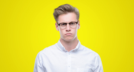Young handsome blond man skeptic and nervous, frowning upset because of problem. Negative person.