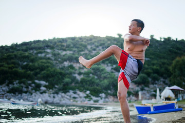 Child shoots the ball in the air at sea beach