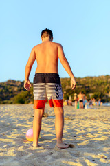 Young boy playing soccer on the beach