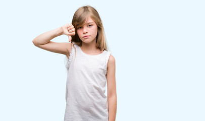 Young blonde toddler with angry face, negative sign showing dislike with thumbs down, rejection concept