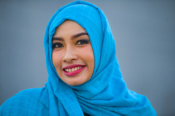 Naklejka premium lifestyle isolated portrait of young beautiful happy Asian woman in hijab muslim head scarf posing to camera playful having fun smiling cheerful