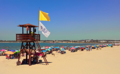 Lifeguard tower with yellow flag.