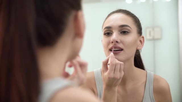 Makeup. Woman Applying Liquid Lipstick On Lips At Bathroom