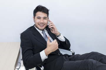 Young handsome businessman smiling  and talking with phone at office .Copy space.