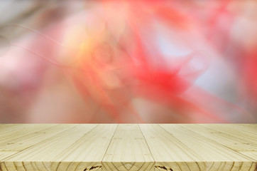 Pine wood table with blurred autumn leaves background.