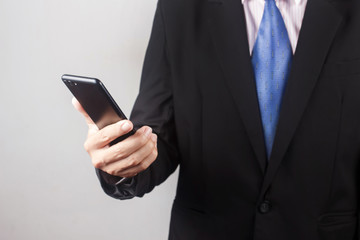 ฺBusiness man using smart phone on gray background