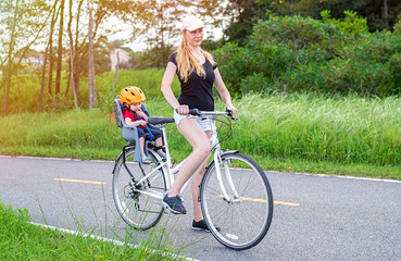 Young mom with baby riding bicycle 